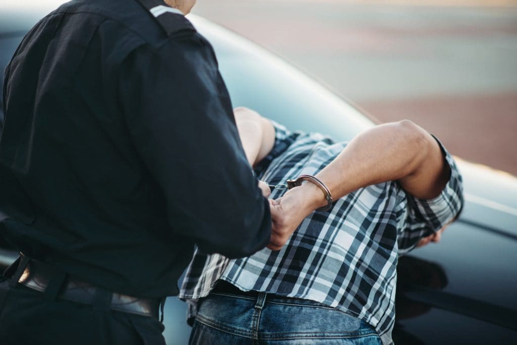 a police officer placing cuffs on a male for a DUI arrest scaled