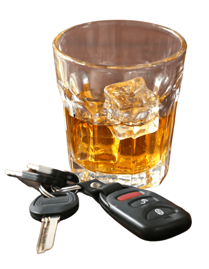Car keys next to a glass with alcohol